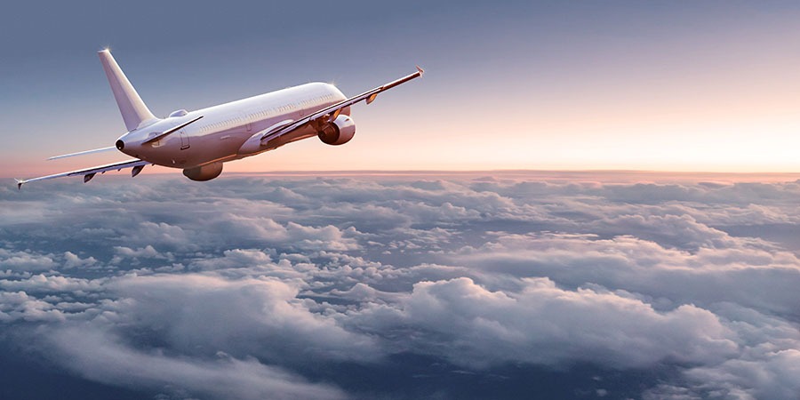 Commercial airplane jetliner flying above dramatic clouds. Commercial airplane jetliner flying above dramatic clouds in beautiful light. Travel concept.