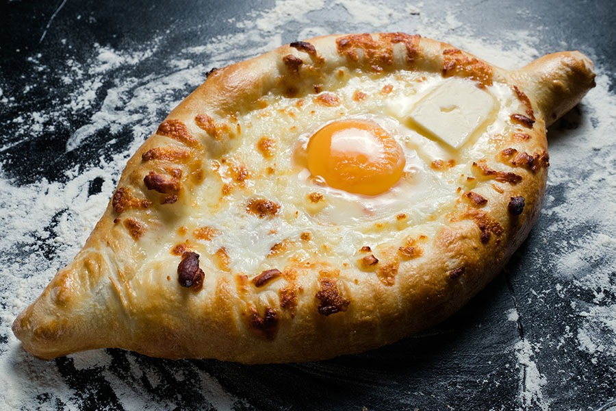 khachapuri adjara traditional Georgian cuisine meal. Baked bread with cheese and egg filling. National pastry snack
